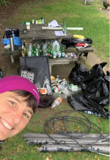 Sarah Pettus with rubbish collected from coastline in the background